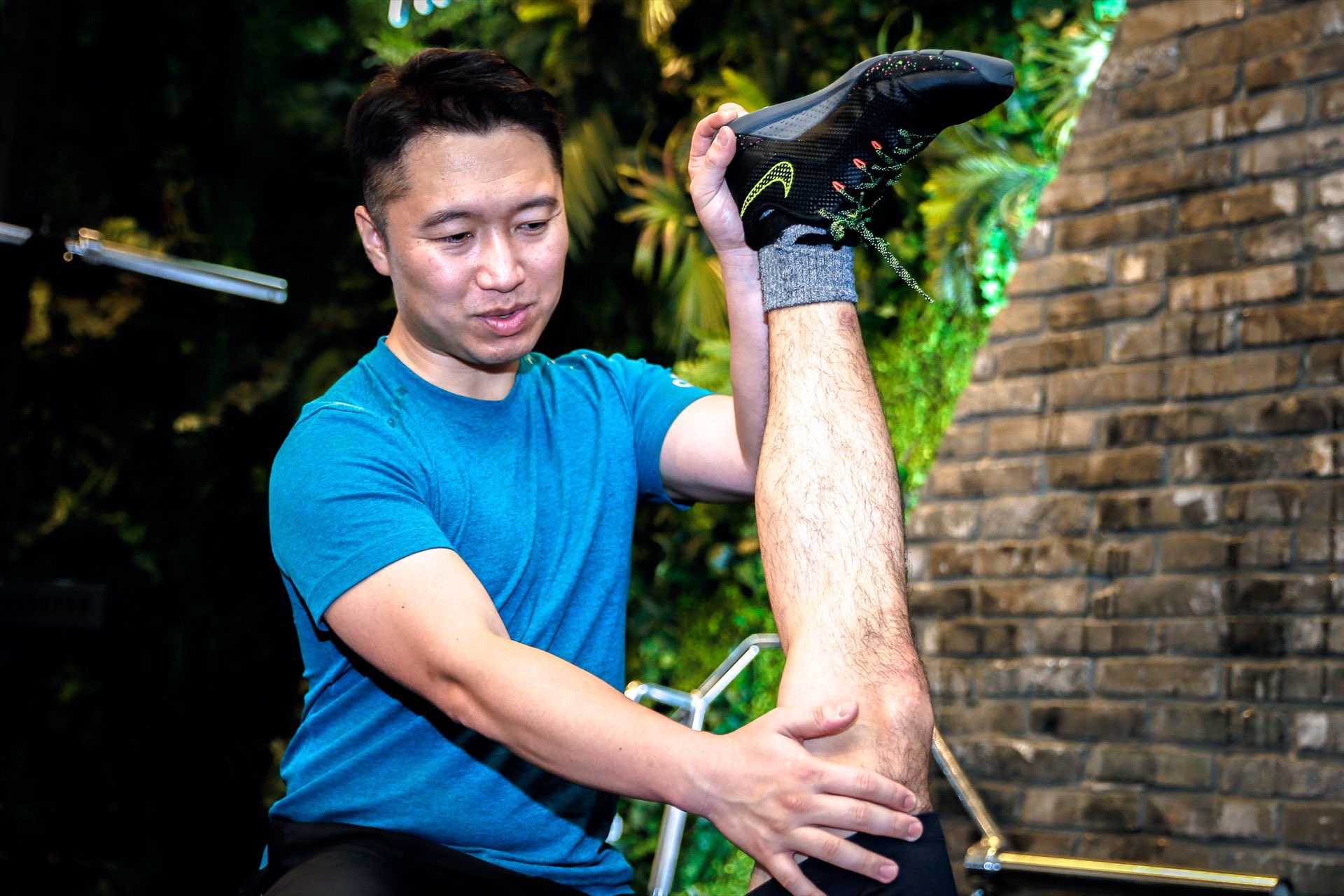 森川稔之がジムでクライアントの股関節ストレッチを補助する様子（TIPNESS三軒茶屋）
