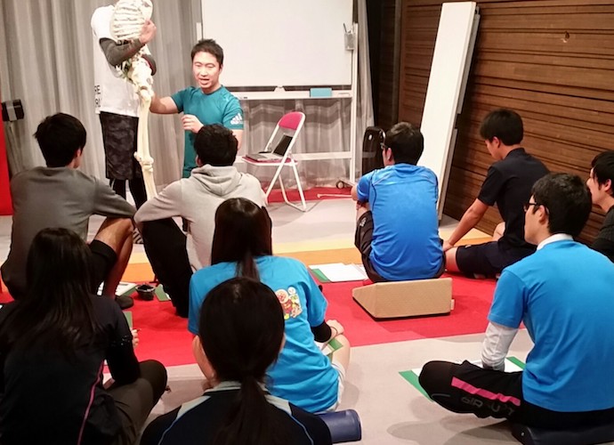 受講者の肩を触診し姿勢を評価する森川稔之